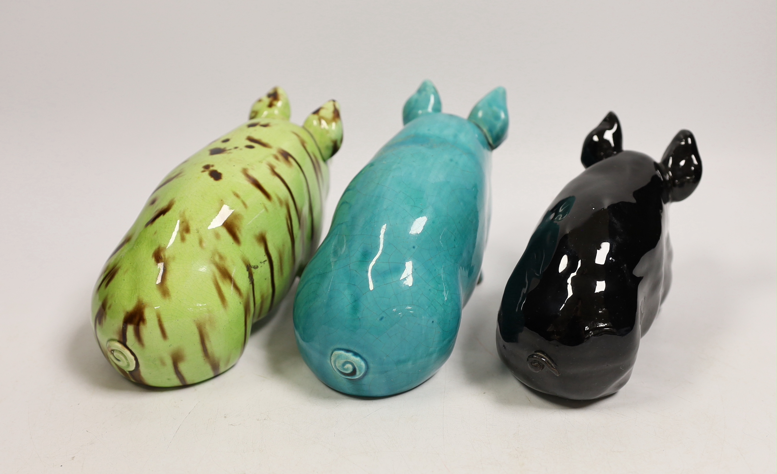 Three Wemyss style pigs in turquoise, pale green / brown and black glazes, one indistinctly marked W.. 15cm